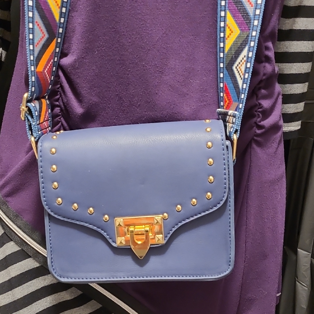 blue crossbody bag with a studded flap and a Seatbelt Style patterned strap